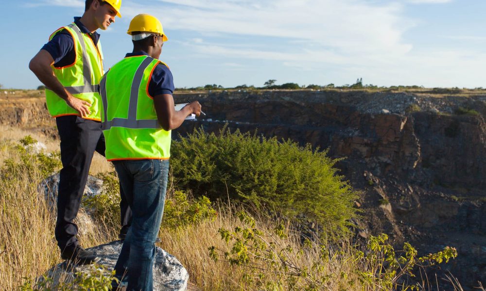 two male surveyors working at mining site
