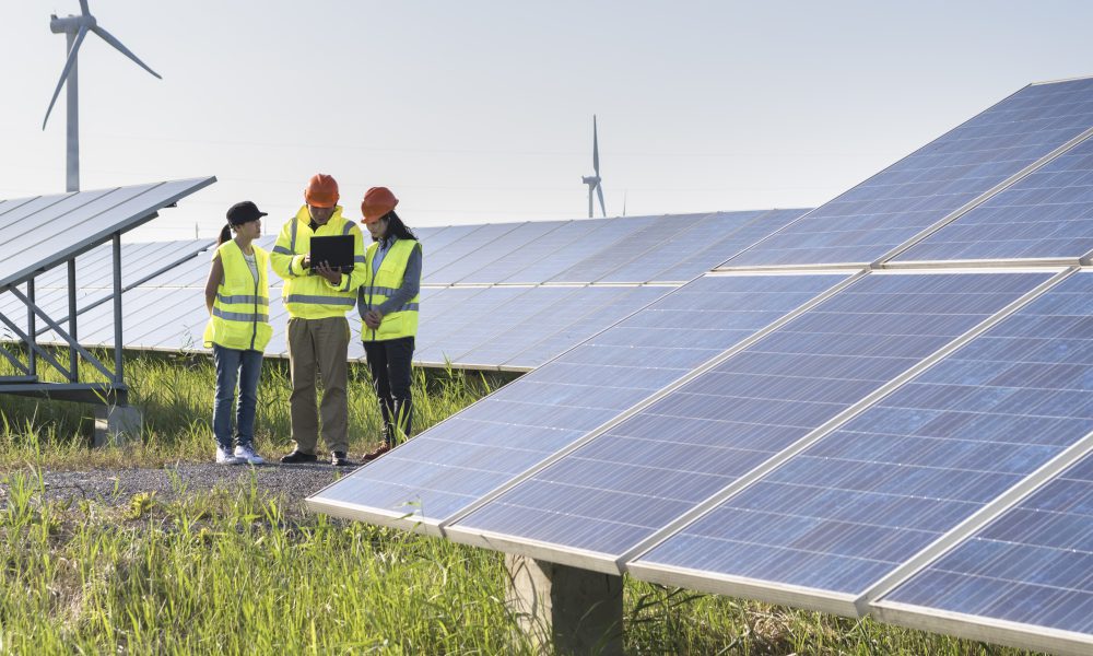 workers at a renewable energy plan, young asian engineers working in solar power station.