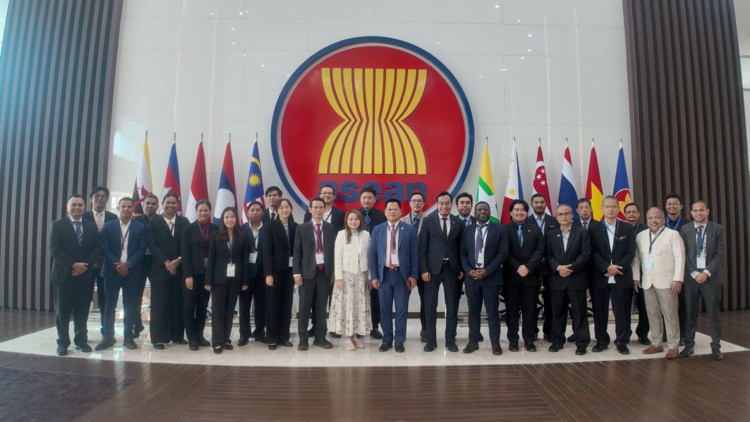 A group of people in front of the ASEAN symbol at the headquarters in Jakarta.