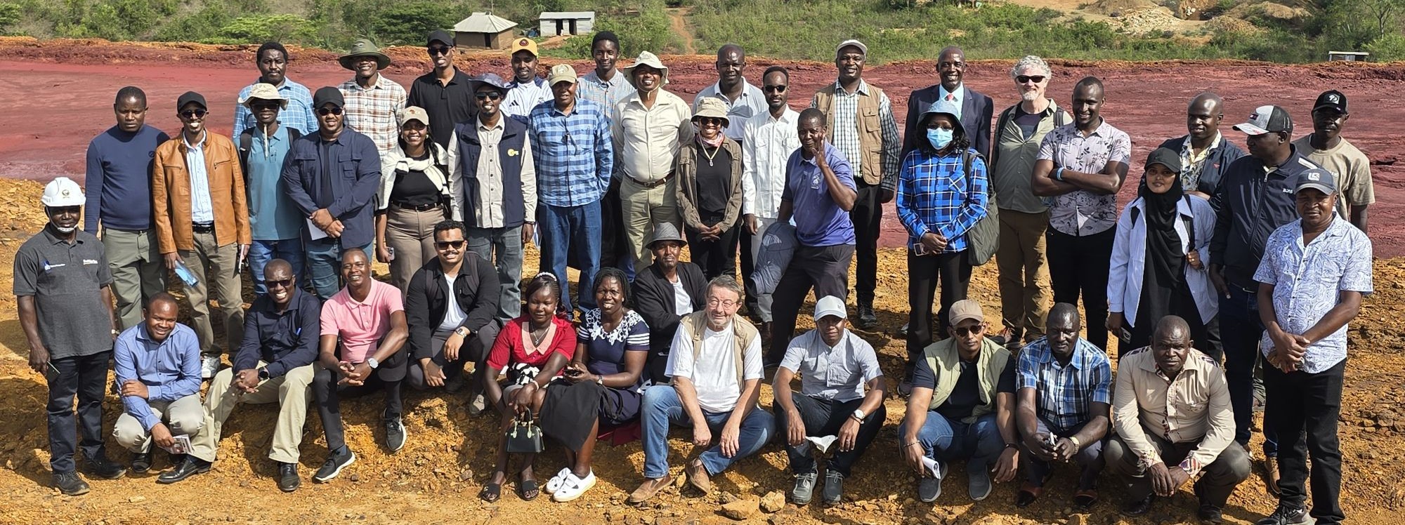 Group of people pose for a photo in a desert area.